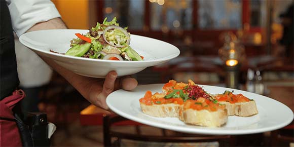 Waiter holding up two plates