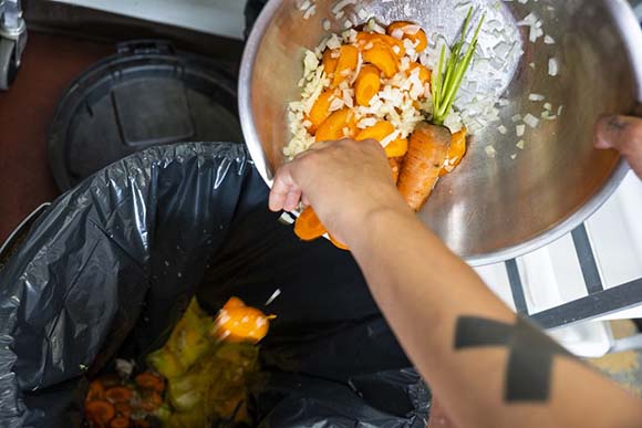 Person throwing food in a bin